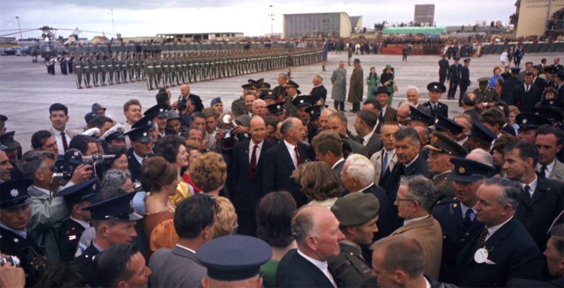 Police and photographers surround JFK at Shannon, as he meets the Bunratty Castle Singers. 